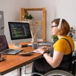 Mujer con discapacidad en silla de ruedas trabajando en remoto